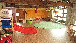 Krippenraum mit Rutsche, Esstisch und Teppich zum Spielen
